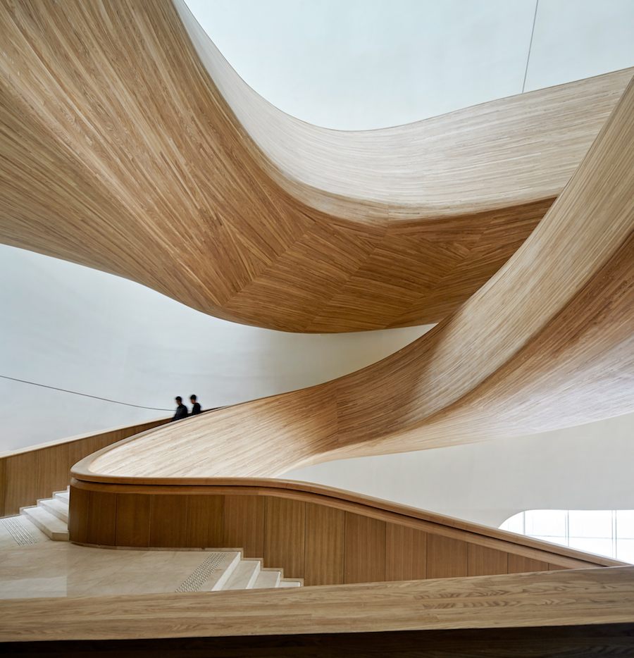 The sculpted wood staircase leading to the grand theater - Photo by: Hufton+Crow.